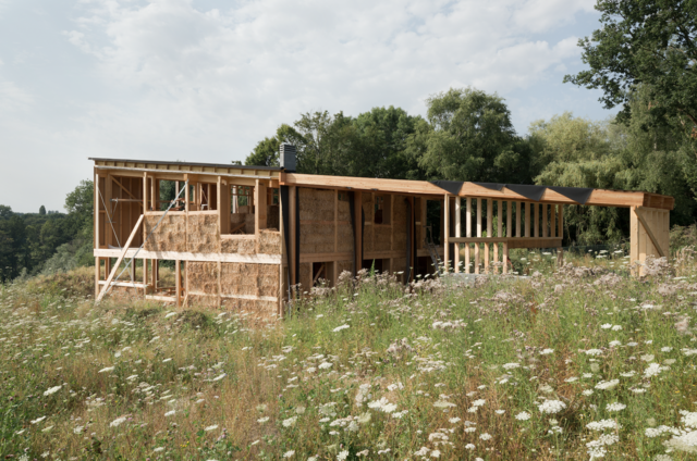 Photo de la maison depuis les champs pendant la pose de la paille